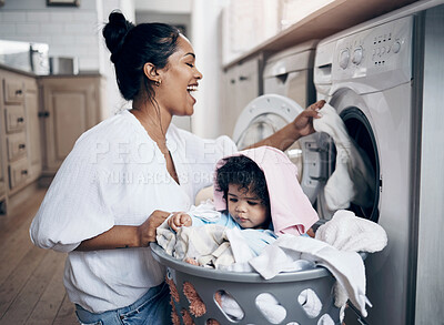 Buy stock photo Mother, infant and playing with laundry in home, help mom and multitasking with chores. Mama, support daughter and housekeeping with child in kitchen, cleaning and loading clothes in washing machine