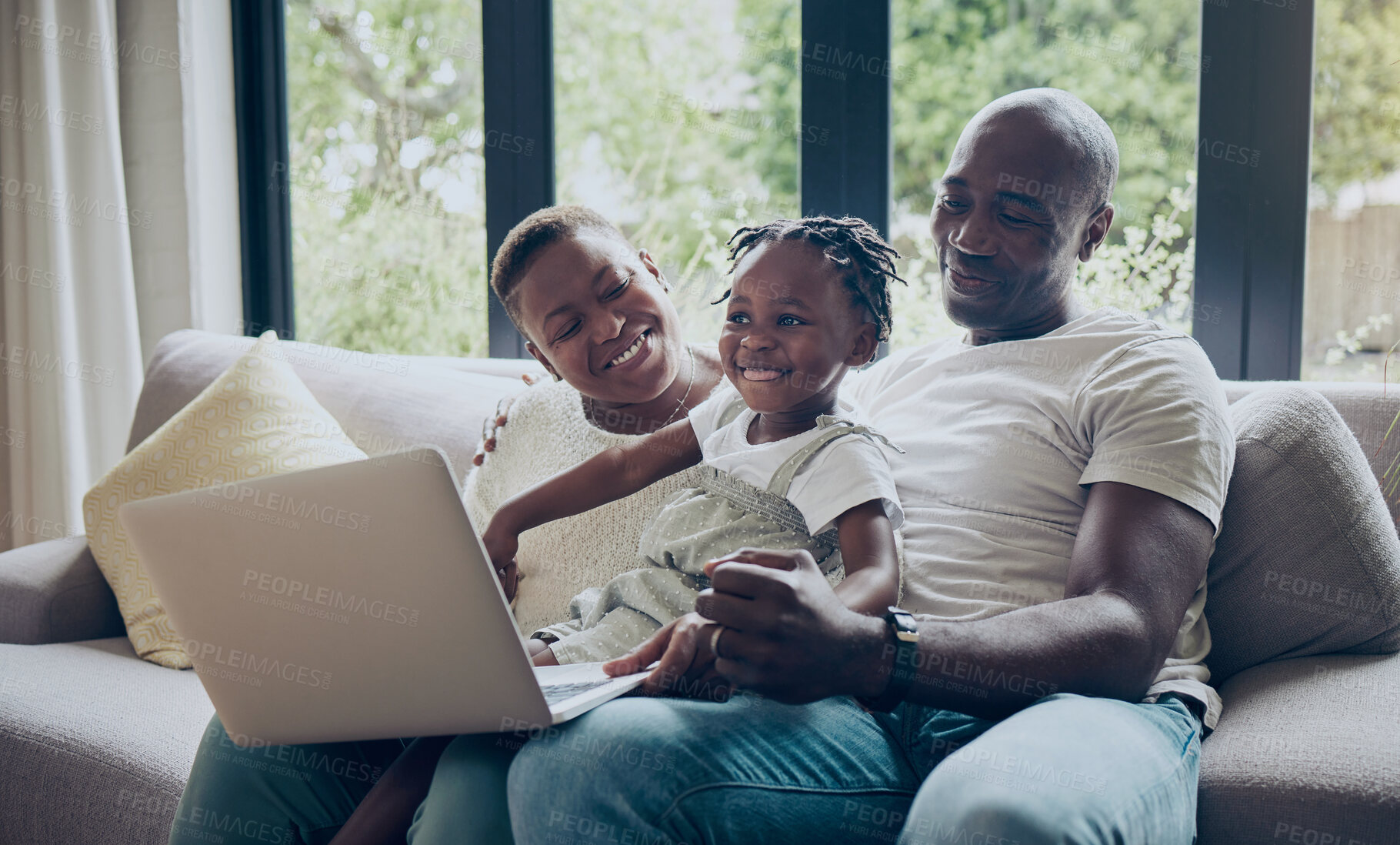 Buy stock photo Shot of a young family using a laptop together at home