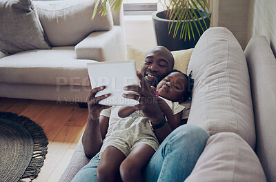 Buy stock photo Shot of a father and daughter using a digital tablet together at home