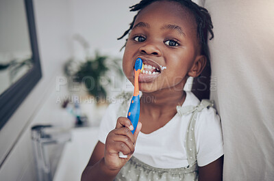 Buy stock photo Shot of a little girl brushing her teeth at home