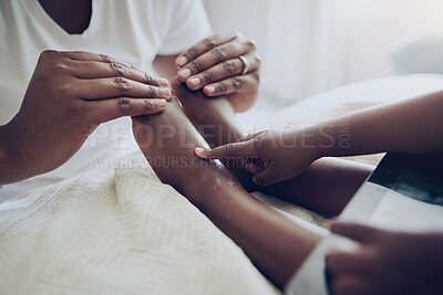 Buy stock photo Shot of an unrecognizable mother applying lotion to her child's feet at home
