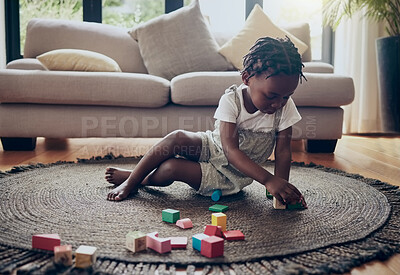 Buy stock photo Shot of a little girl playing with blocks at home
