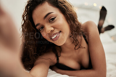 Buy stock photo Shot of a woman taking a selfie while lying in lingerie