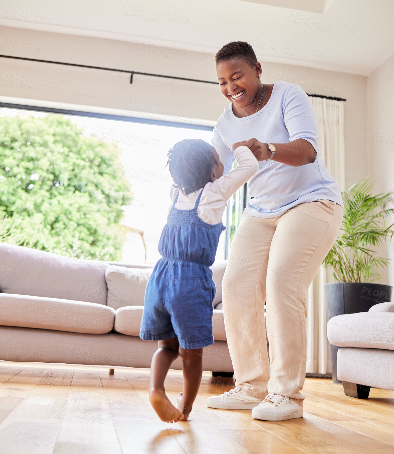 Buy stock photo Mother, happy and dancing with child in living room, woman and toddler daughter for movement holding hands in apartment. Relationship, childhood and moving in lounge for music, weekend and smile