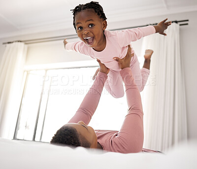 Buy stock photo Shot of a beautiful young woman bonding with her daughter in bed at home