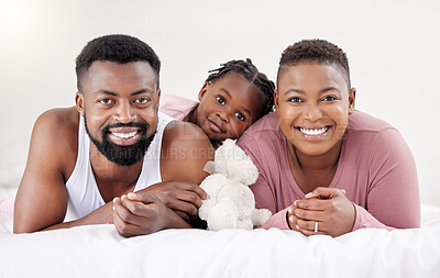 Buy stock photo Shot of a young family bonding in bed together