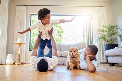 Buy stock photo Dad, mother and home playing airplane together with happiness and puppy with smile. House, family and support of a mom, father and young child with dog and animal in living room having fun on floor