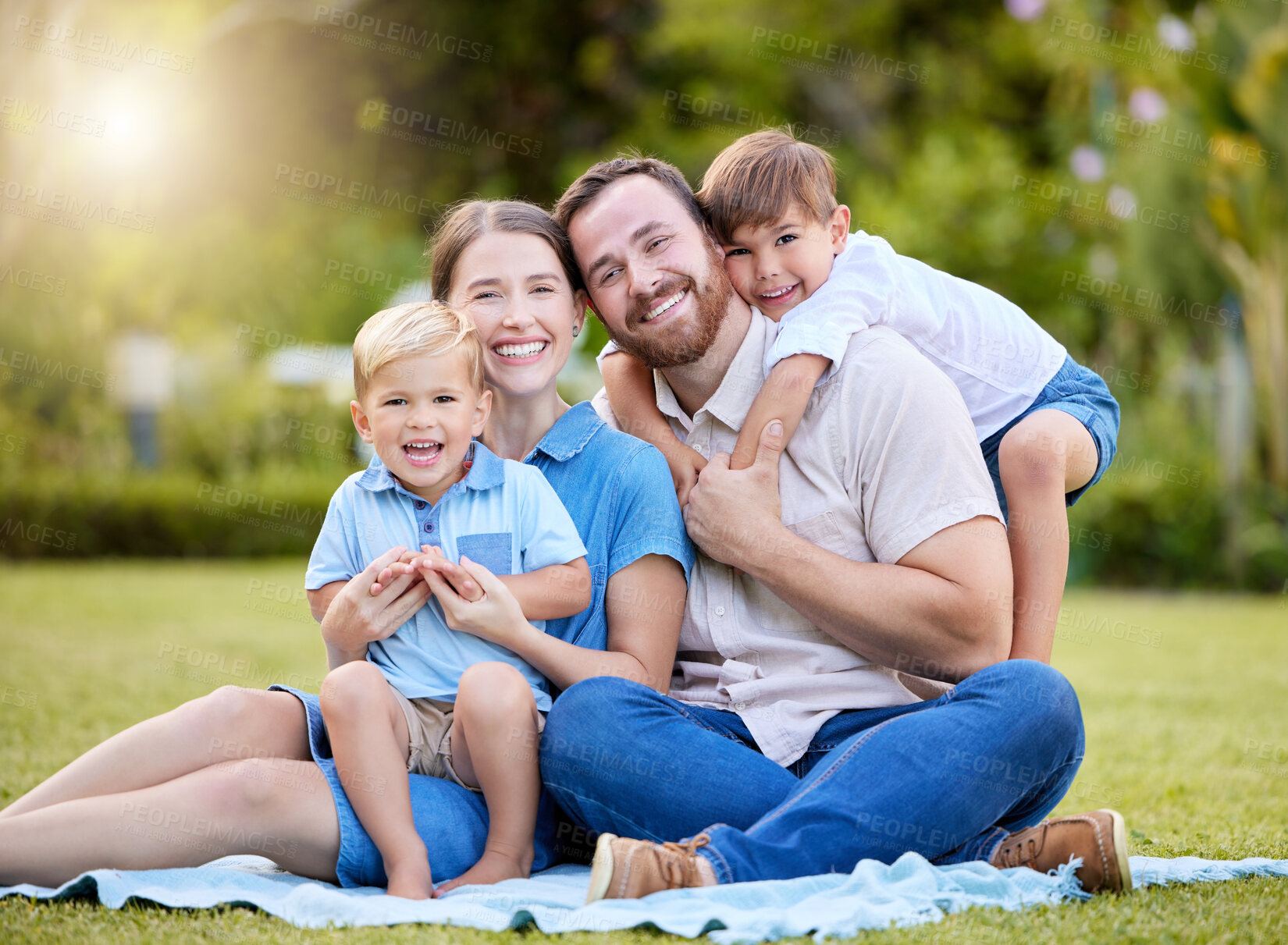 Buy stock photo Happy, relax and portrait of family in nature with hug, love and care for bonding together. Smile, picnic and boy children with parents sitting on blanket by grass in outdoor park, field or garden.