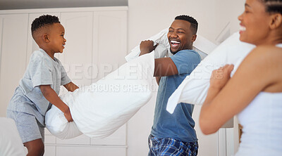 Buy stock photo Shot of a happy family having a pillow fight together at home