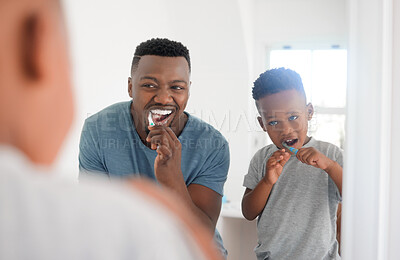 Buy stock photo Black man brushing his teeth with his kid for dental hygiene, health and wellness in the bathroom. Oral care, teaching and young African father doing morning mouth routine with his boy child at home.