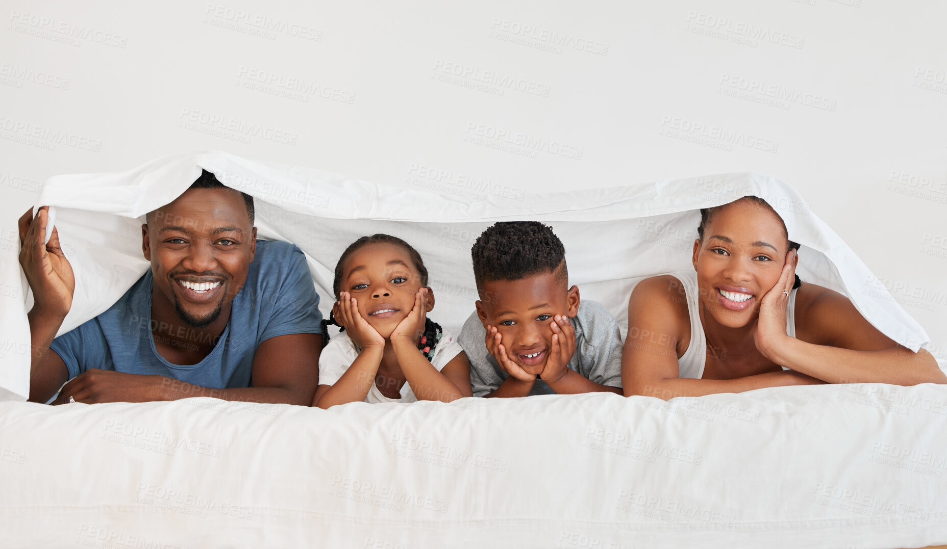 Buy stock photo Portrait of a happy family relaxing under a blanket together at home