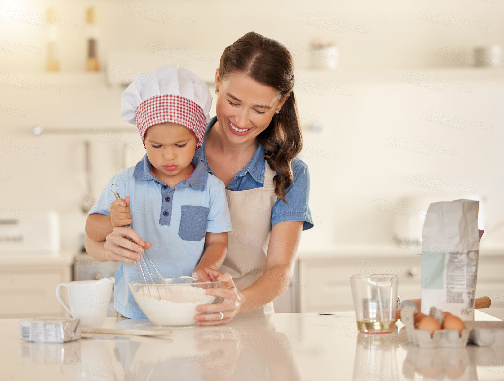 Buy stock photo Shot of a young mother baking with her son