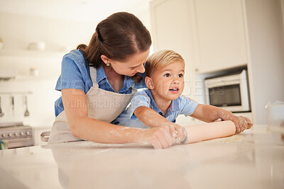 Buy stock photo Shot of a young mother rolling out dough with her son