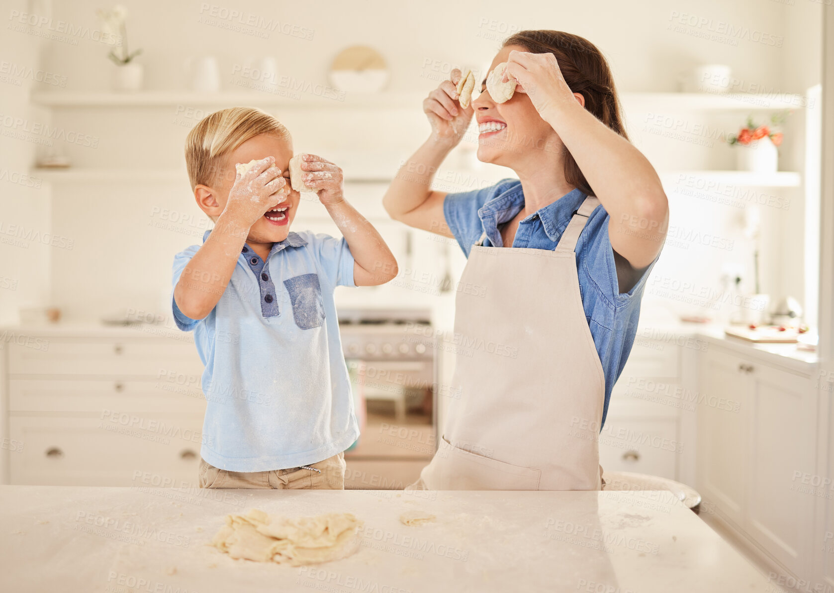 Buy stock photo Shot of a mother and son playing with dough together while baking