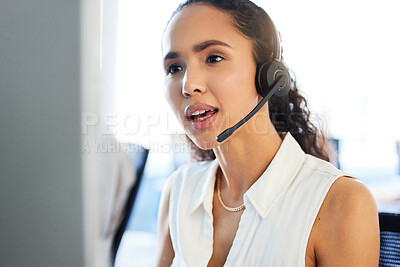 Buy stock photo Shot of an attractive young call centre agent sitting in the office and using her computer