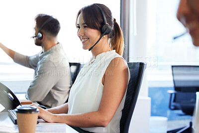 Buy stock photo Shot of an attractive young call centre agent sitting in the office with her colleagues