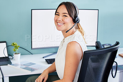 Buy stock photo Shot of an attractive young call centre agent sitting alone in the office and using her computer