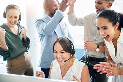 Buy stock photo Shot of an attractive young call centre agent sitting and celebrating a success while her team support her