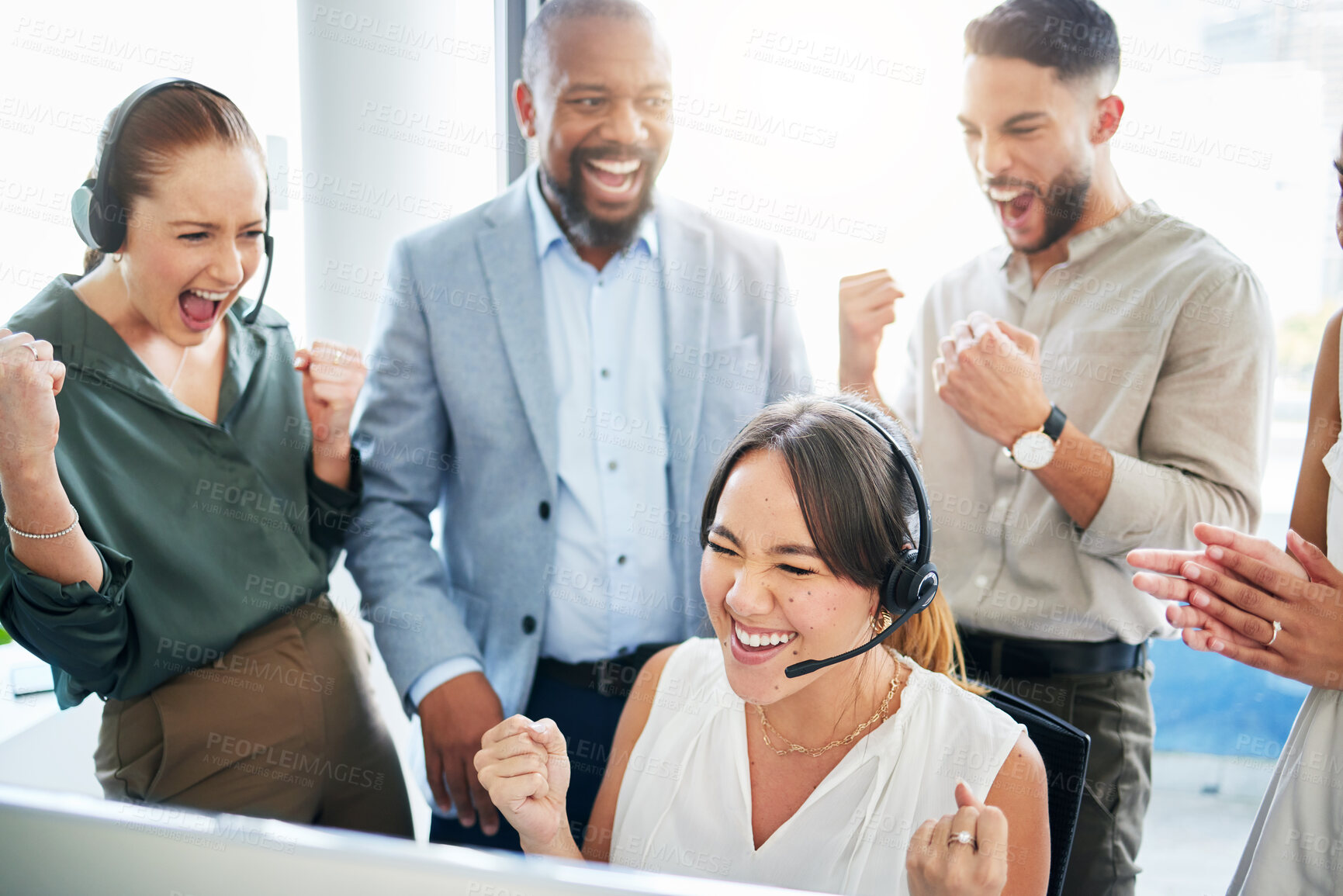Buy stock photo Shot of an attractive young call centre agent sitting and celebrating a success while her team support her