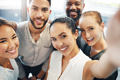 Buy stock photo Shot of a diverse group of businesspeople standing together in the office and taking selfies