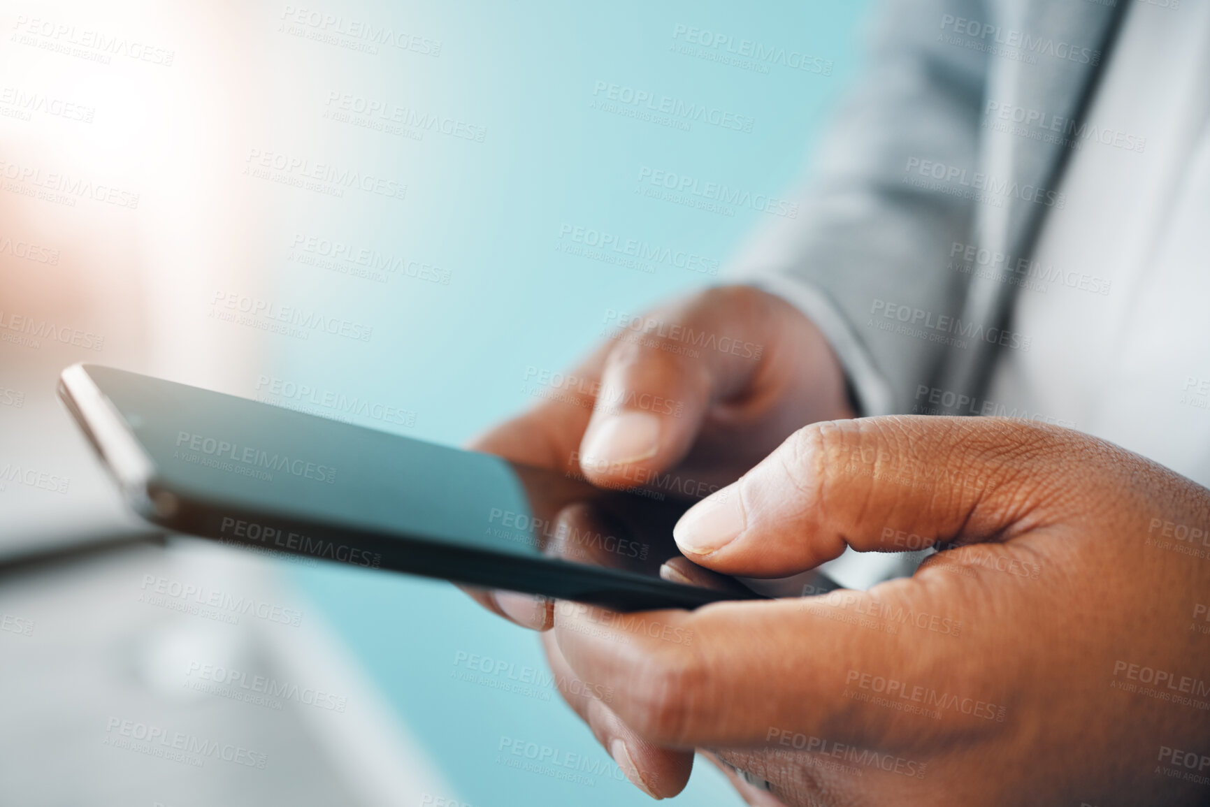 Buy stock photo Cropped shot of an unrecognisable businessman standing alone in the office and using his cellphone