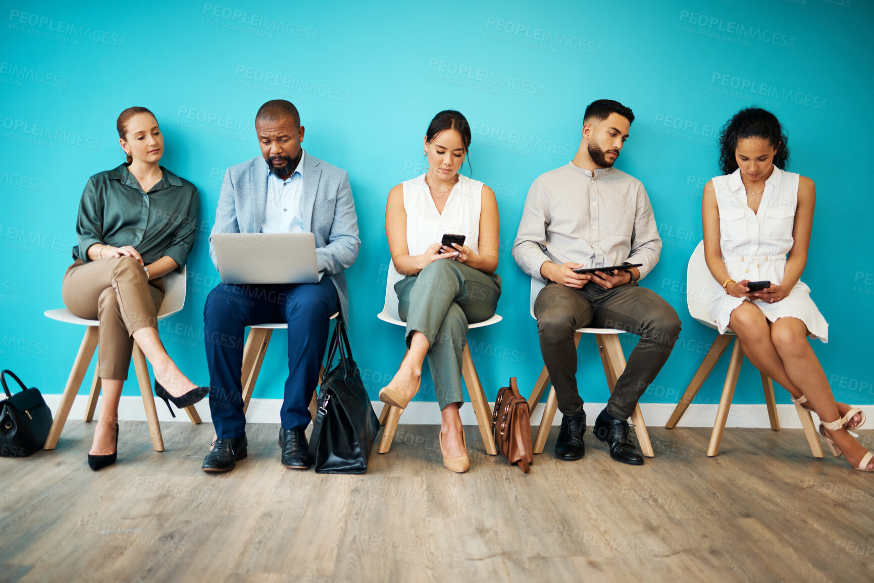 Buy stock photo Full length shot of a diverse group of businesspeople sitting together in the office and using technology