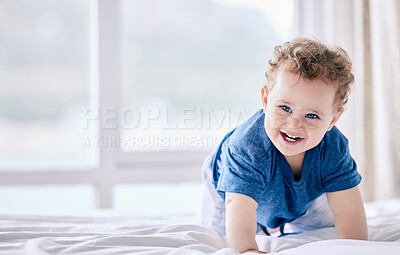 Buy stock photo Shot of an adorable little boy crawling on the bed at home