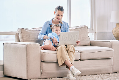 Buy stock photo Shot of a woman using her laptop while sitting at home with her daughter