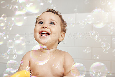 Buy stock photo Bubbles, baby and happy in bathroom for bath, cleaning and hygiene with night time routine for growth or development. Toddler, home and washing in bathtub for skin care, cute and playful in house