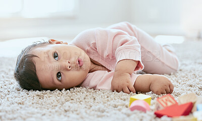 Buy stock photo Shot of an adorable baby girl lying on the floor at home