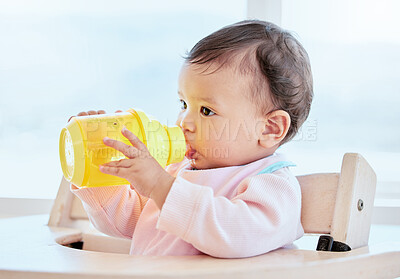 Buy stock photo Shot of a sweet baby girl drinking a bottle at home