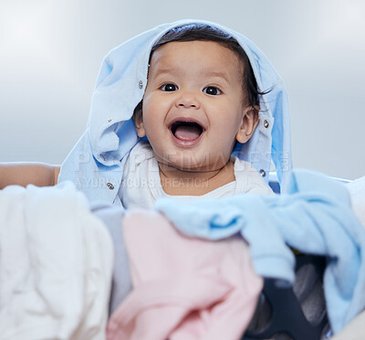 Buy stock photo Shot of an adorable little girl playing in fresh laundry at home