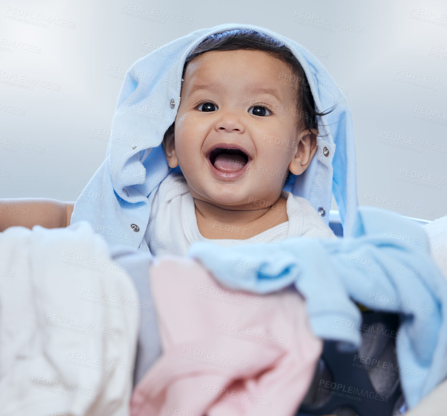 Buy stock photo Baby, child and play with laundry in portrait with smile, learning and development with fun in morning. Kid, infant and excited with clothes, basket and happy with growth at family house in Indonesia