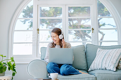 Buy stock photo Full length shot of an attractive young woman listening to music while relaxing on the sofa at home