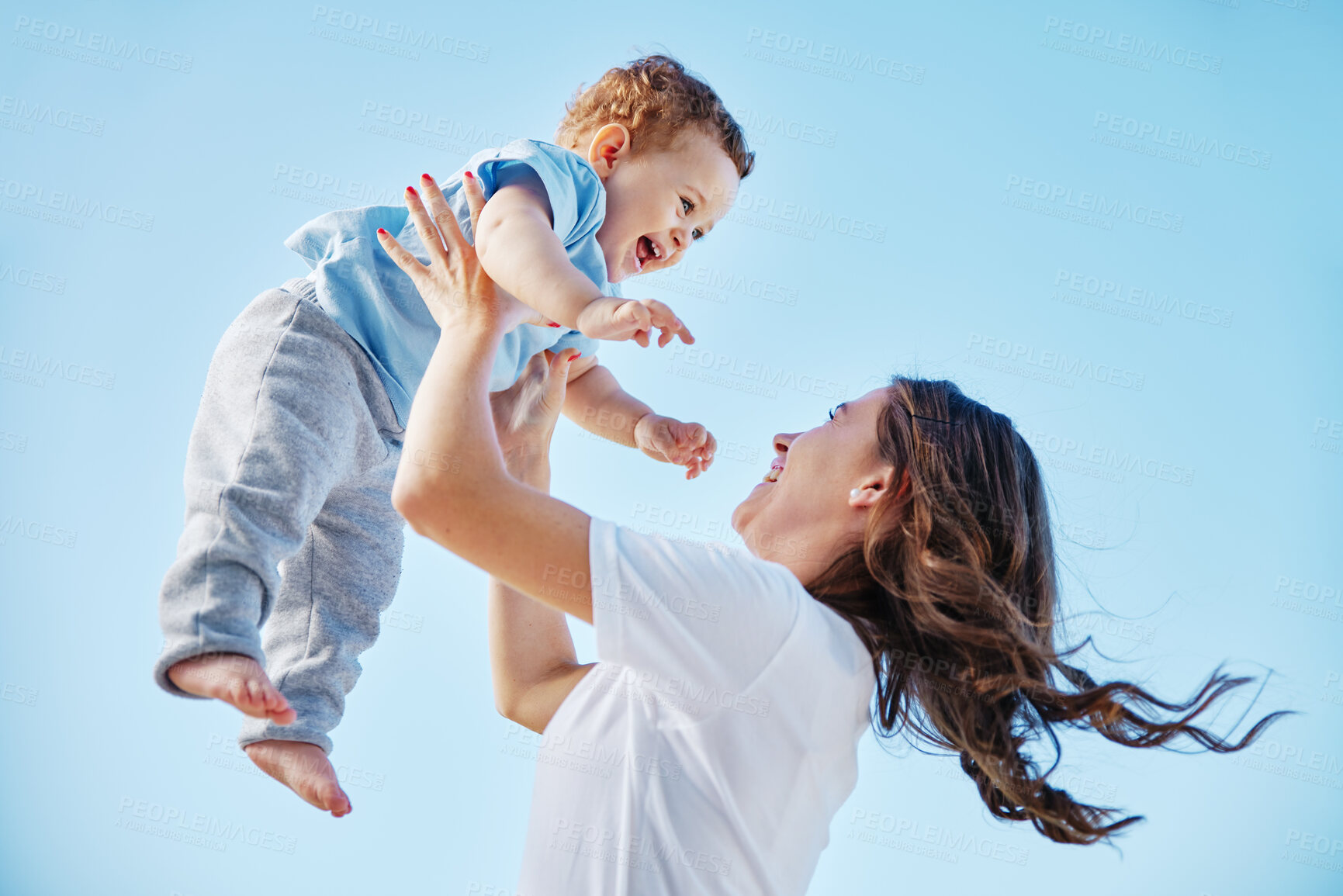 Buy stock photo Cropped shot of an attractive young woman and her adorable baby boy playing outside