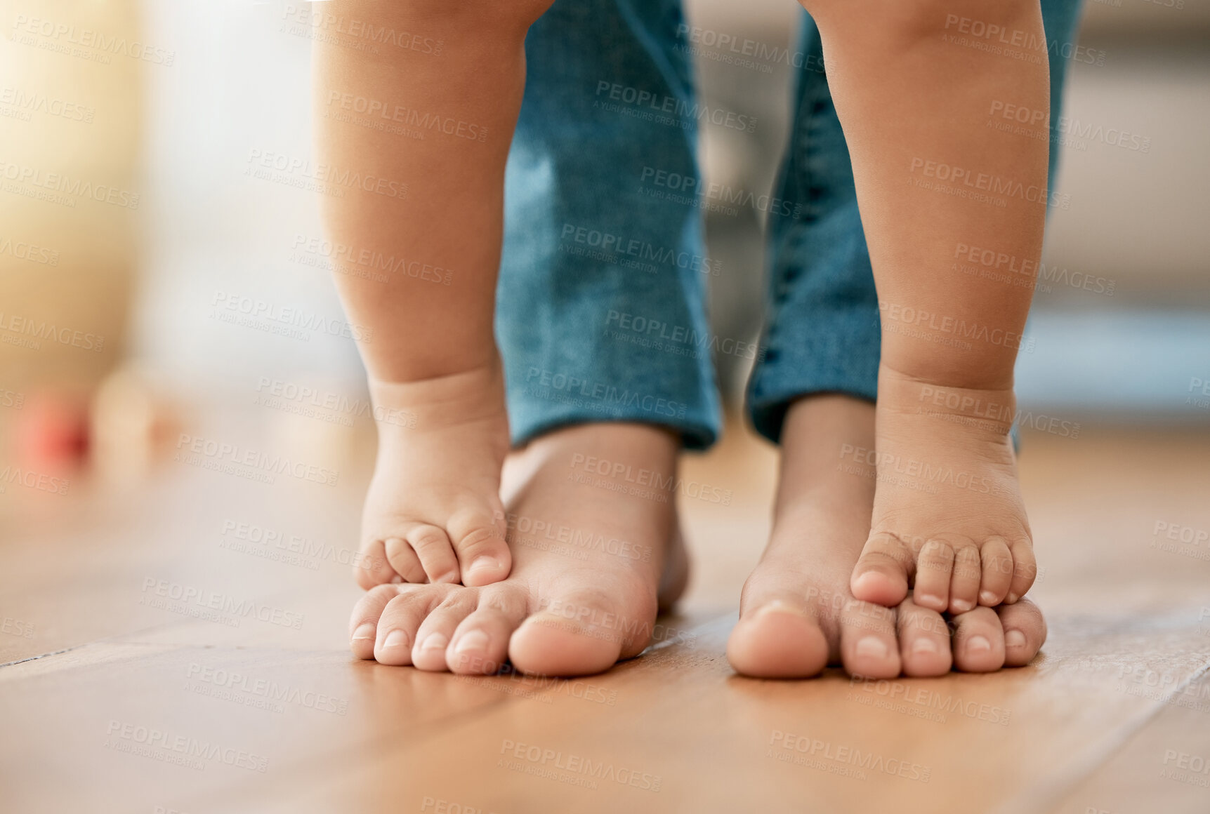 Buy stock photo First steps, feet and baby with mom for trust, growth and guidance in living room. Person, toddler and standing together at home for learning, motor skills and child development at home with support