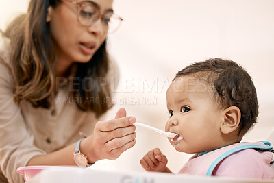 Buy stock photo Shot of a woman feeding her baby at home
