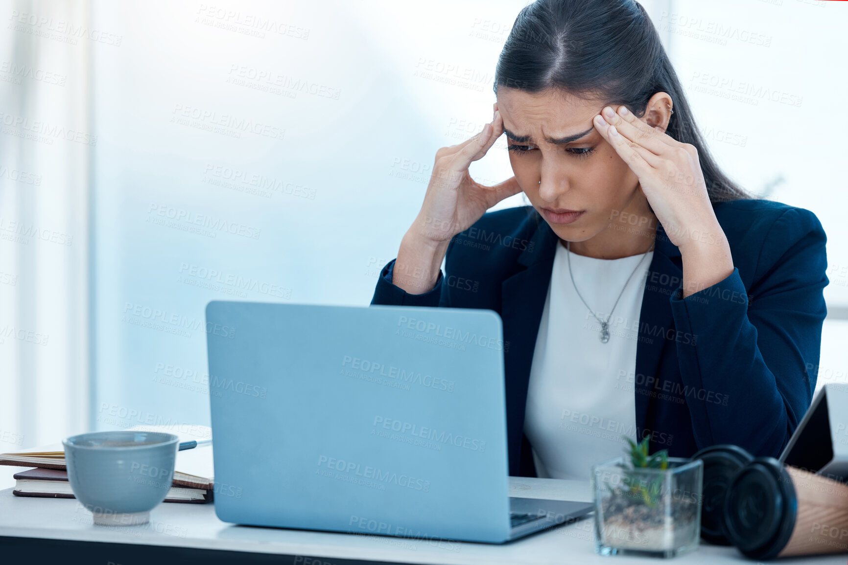 Buy stock photo Shot of a young businesswoman looking stressed out while working on a laptop in an office