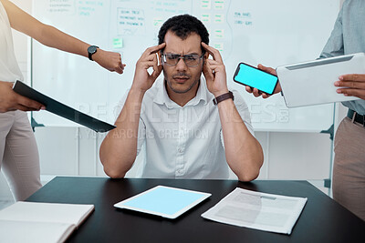 Buy stock photo Shot of a young businessman looking stressed out while working in a demanding office environment