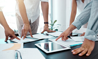 Buy stock photo Closeup shot of a group of unrecognisable businesspeople going through paperwork in an office