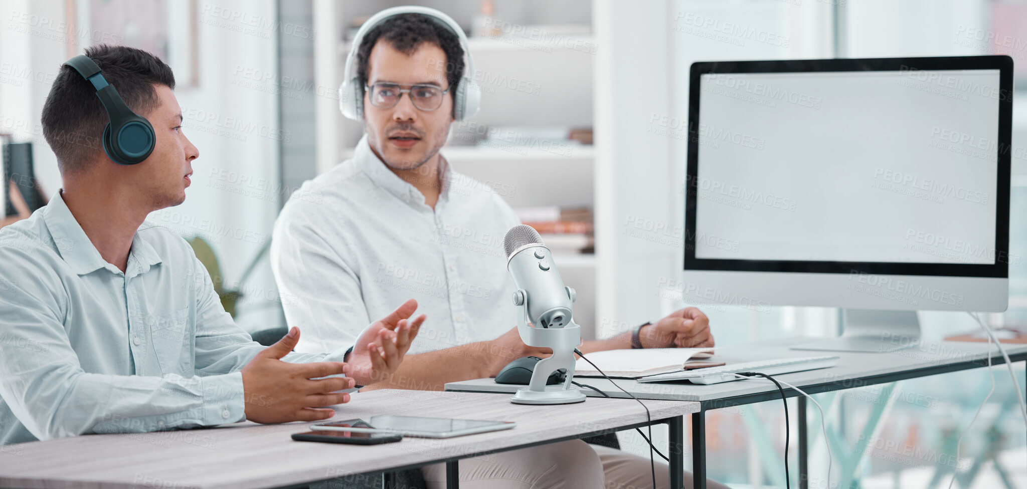 Buy stock photo Shot of two young men doing a broadcast in an office