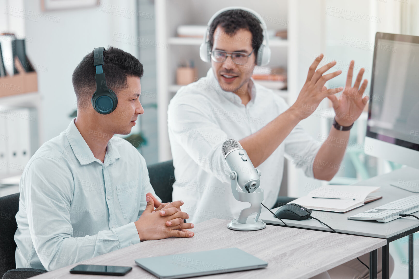 Buy stock photo Shot of two young men doing a broadcast in an office