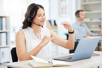 Buy stock photo Shot of a young businesswoman wearing a headset while having a video call on a laptop in an office