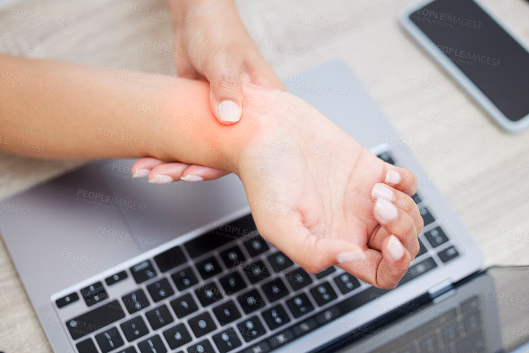 Buy stock photo Closeup shot of an unrecognisable businesswoman experiencing wrist pain while working on a laptop in an office
