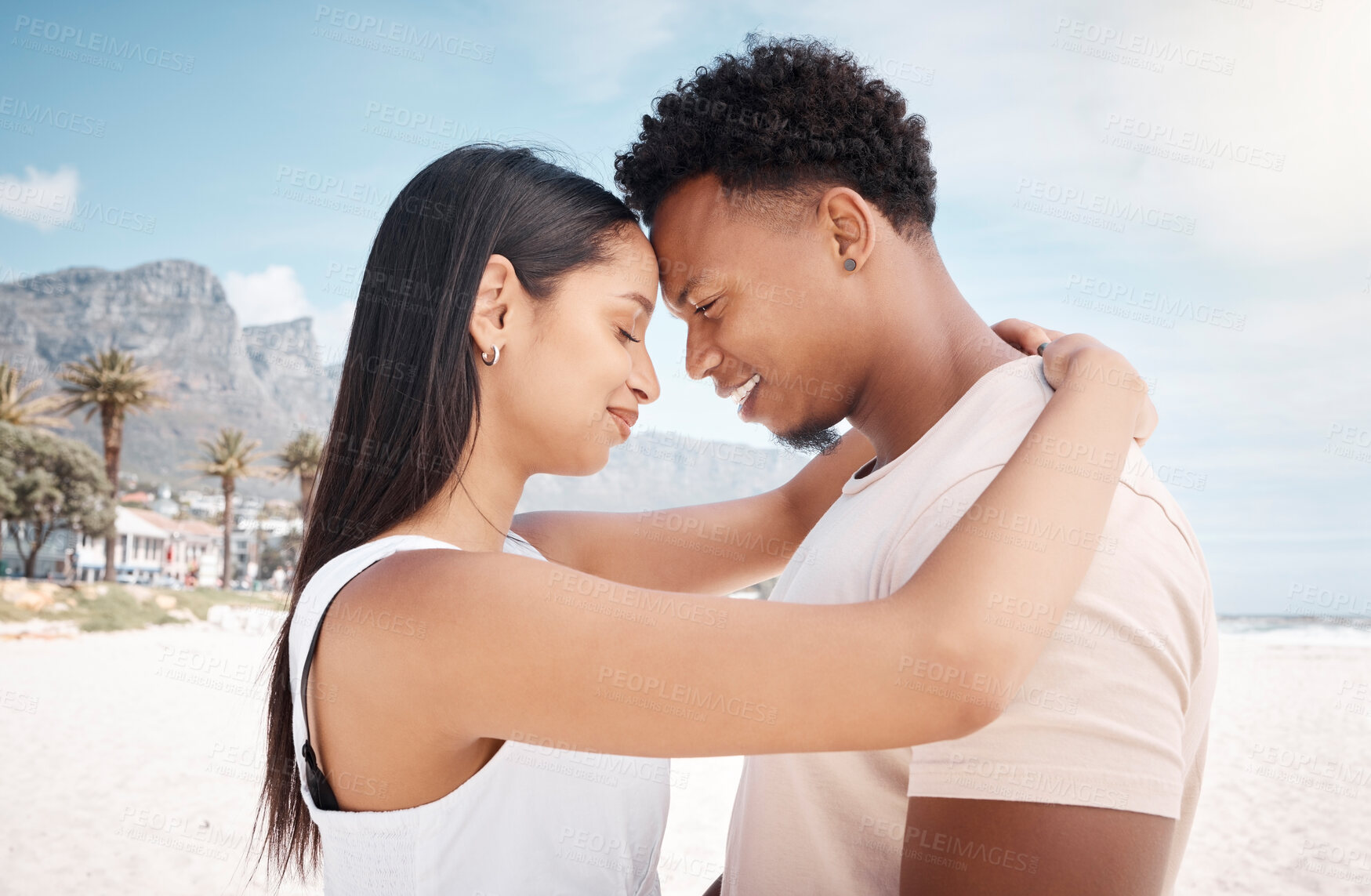 Buy stock photo Couple, travel and forehead touch at beach, hug and support for ocean bonding. People, romance and love for marriage on vacation at sea, profile and holiday embrace for trust on tropical weekend