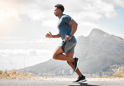 Buy stock photo Shot of a handsome young man running alone outdoors