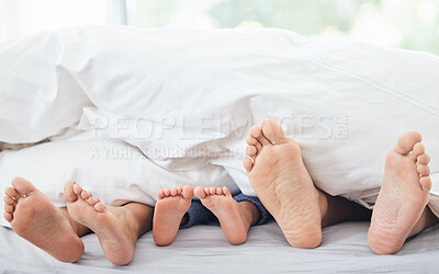 Buy stock photo Cropped shot of a little girl lying between her mother and father on their bed