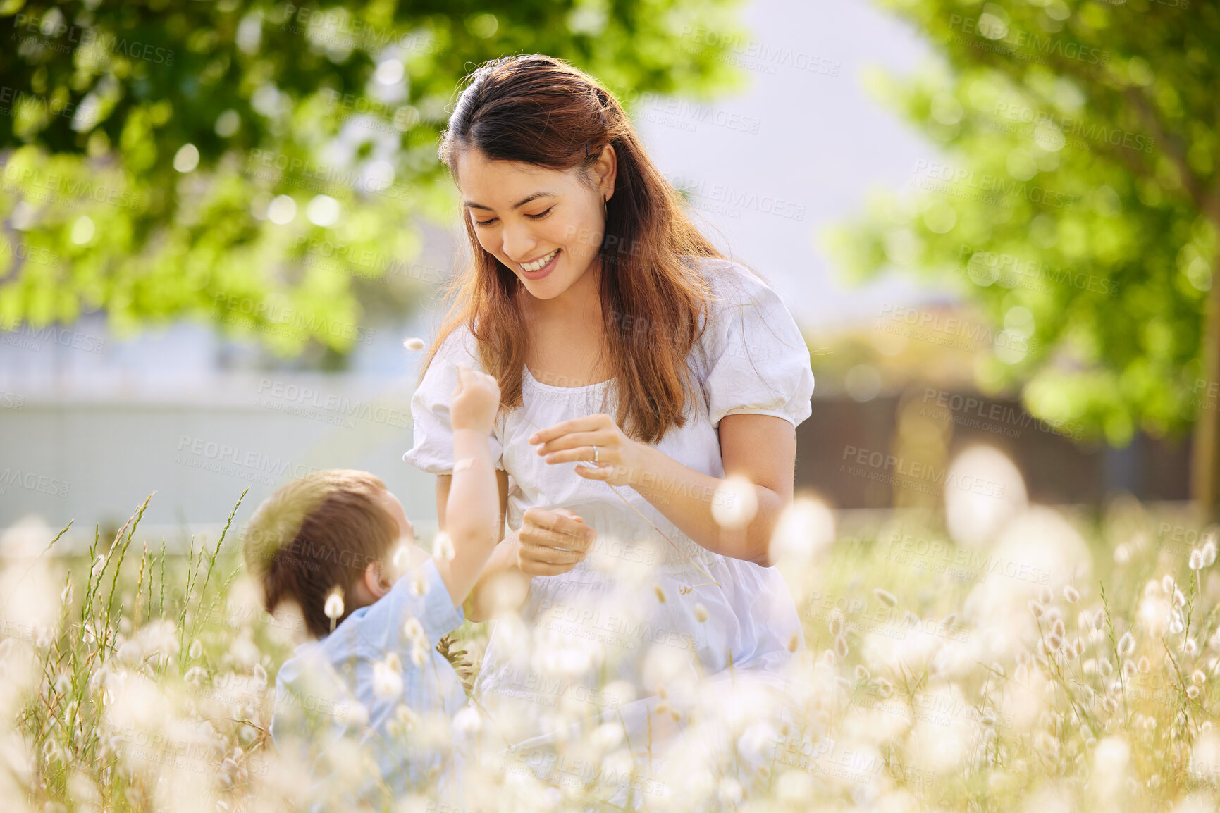 Buy stock photo Mother, boy and flowers in nature together for love, security and bonding in outdoor for spring plants. Mommy, son and happiness in field or holiday in countryside, peace and freedom on vacation