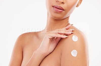 Buy stock photo Shot of a unrecognizable woman applying moisturizer to her shoulder against a grey background