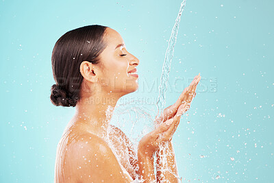 Buy stock photo Shot of an attractive young woman showering against a blue background